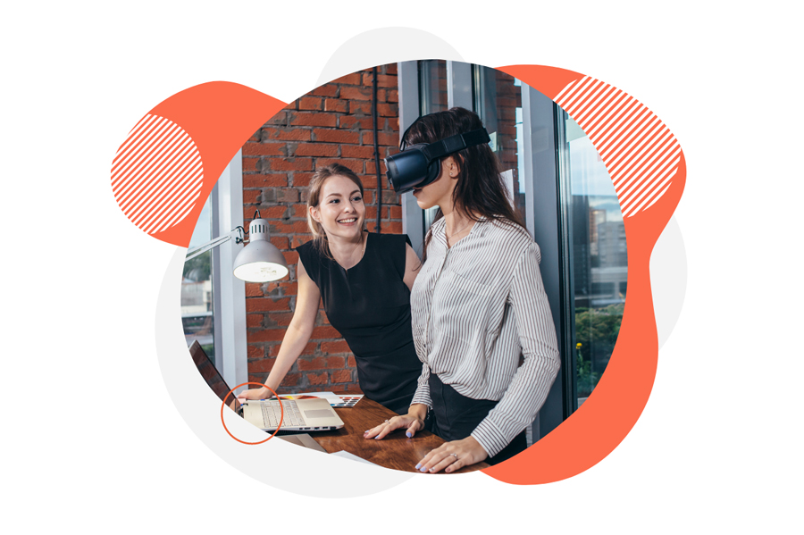 Two women in office, one wears a vr headset